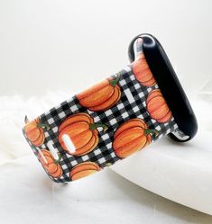 a black and white checkered apple watch band with pumpkins on it