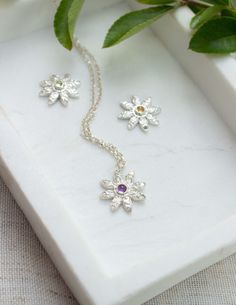 These stunning Birthstone Daisy pendants are a piece of jewellery you didn't realise you needed to add to your jewellery collection. With their unbelievable beauty from the handcrafted delicate detailed flower which is complimented by a gorgeous pop of colour with a 3mm gemstone of your choice giving them a thoughtful touch, making this the perfect unique and personal gift you was after.  In the photos you can see Three birthstones, Peridot, Amethyst and Citrine but more birthstones are availabl Silver May Birthstone Pendant Necklace, Dainty Flower-shaped Birthstone Jewelry, Silver May Birthstone Necklace As A Gift For Her, Dainty Sterling Silver Birthstone Necklace For Mom, Silver Pendant Necklace For May Birthstone, Sterling Silver Pendant Birthstone Necklace For Her, Sterling Silver Birth Flower Necklaces, Sterling Silver White Necklace For May Birthstone, White Sterling Silver Necklace For May Birthstone