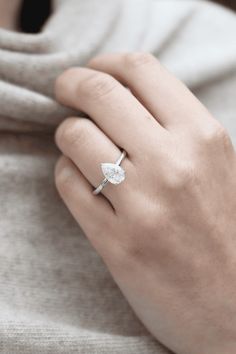 a woman's hand wearing a ring with a leaf design on the middle finger