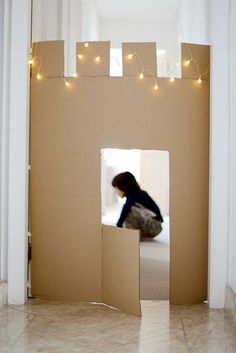 a person is sitting on the floor in a cardboard castle