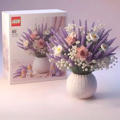 a white vase filled with flowers next to a box