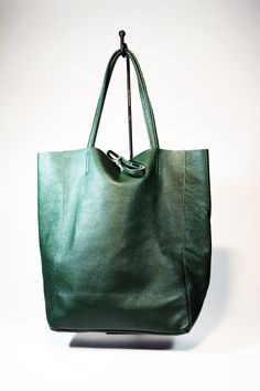 A lightweight and spacious Leather Shopping Bag-Green you can use for your office, gym and after-hours essentials while still looking stylish. Handmade from supple calfskin Italian leather, the versatile look features over-the-shoulder handles and minimal detailing. Raw edges and no lining makes this style super light and easy to fold when traveling. Inside is a zippered document pouch and a leather cell phone pouch. Details: Color: Green Two leather strap for closing the bag.Natural unlined int Modern Textured Leather Bucket Bag For Shopping, Leather Bucket Tote Bag For Office, Minimalist Shopping Bags With Rolled Handles, Versatile Textured Leather Bucket Bag For Shopping, Office Tote Bucket Bag With Smooth Grain, Office Bucket Bag With Smooth Grain In Tote Style, Minimalist Shoulder Bag With Leather Lining For Work, Minimalist Workwear Shoulder Bag With Leather Lining, Minimalist Leather-lined Shoulder Bag For Work