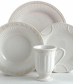 a white dinner set consisting of plates and cups