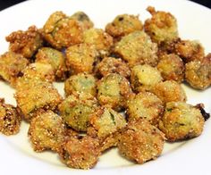 a white plate topped with fried food on top of a table