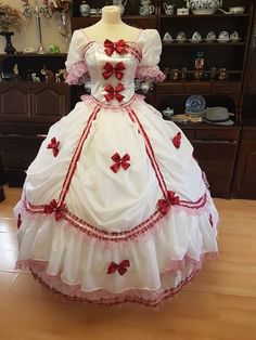 This Original dress is inspired by historical fashion around 1860. It is 100% handmade original. It is made from white polyester. It is decorated with dark red bow, lace, fliters and pink stones. The dress size is 36 - 40 ( Euro sizes )  S - L . Corset is boned and laced up at rear, therefore there is no need for under garment. At the back, the dress is laced. Skirt is buttoned up and adjustable  to suit your size. Dress is very light and extremely comfortable to wear.  Not included undergarment Pink Victorian Ball Gown Costume Dress, Pink Victorian Ball Gown Costume, White Regency Costume Dress, White Regency Style Costume Dress, Victorian White Ball Gown Dress, White Victorian Ball Gown Dresses, Marie Antoinette Style White Dress For Costume Party, Victorian White Ball Gown, Pink Victorian Dress Costume