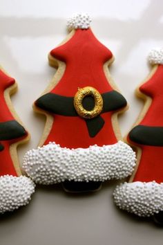 three decorated cookies in the shape of christmas trees