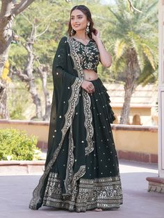 Introducing the epitome of elegance and grace, behold the dark green Georgette lehenga ensemble adorned with intricate sequin and embroidered work, perfect for your mehendi celebrations. Crafted with meticulous attention to detail, this ensemble exudes sophistication and charm, promising to make you the cynosure of all eyes on your special day.
The dark green Georgette lehenga boasts a mesmerizing 3.5-meter flair, ensuring graceful movements with every step you take. Its exquisite sequin and emb Dark Green Bollywood Traditional Wear For Festive Season, Dark Green Festive Sets For Eid, Dark Green Traditional Wear For Wedding In Festive Season, Dark Green Traditional Wear For Wedding Festivities, Dark Green Traditional Wear For Wedding And Festivals, Dark Green Traditional Wear For Festive Wedding, Festive Dark Green Traditional Wear For Wedding, Dark Green Dupatta For Wedding And Festivals, Dark Green Traditional Wear For Wedding