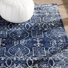 a large blue rug with an ornate design on it and a white poufce