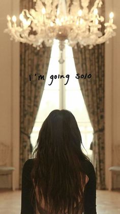 a woman sitting in front of a chandelier with the words i'm going solo