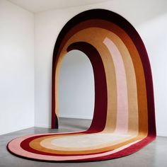 an unusual rug is in the middle of a room with white walls and flooring