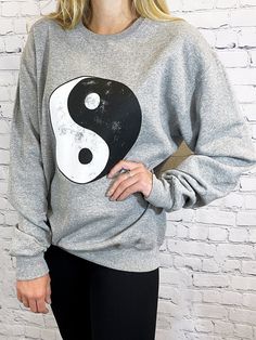 About -Oversized -50% Cotton 50% Polyester -Hand Wash -Crewneck Pullover -Distressed Ying Yang Graphic It's time to pull out your 90's nostalgia out of the back of the closet. We are in love with this oversized crew neck sweatshirt with a distressed ying-yang graphic at the front. We love this paired with a pair of bike shorts or leggings for a casual style for any day of the week. Distressed Crew Neck Sweater For Streetwear, Oversized Distressed Crew Neck Sweatshirt, Distressed Oversized Crew Neck Sweatshirt, Acid Wash Crew Neck Sweatshirt For Loungewear, Distressed Crew Neck Sweatshirt For Streetwear, Casual Distressed Crew Neck Sweater, Distressed Grunge Crew Neck Sweatshirt, Distressed Crew Neck Sweatshirt In Grunge Style, Casual Distressed Crew Sweatshirt