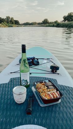 a bottle of wine sitting on top of a boat next to some food and drink