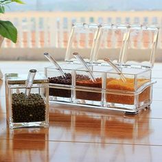 three clear containers filled with spices on top of a wooden table