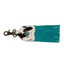 a key chain with a cow print and turquoise tassel