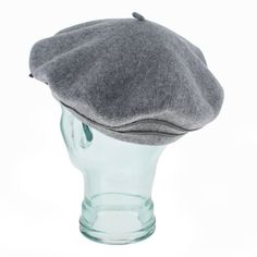 a gray hat sitting on top of a glass head mannequin's head