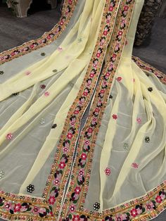 Pale yellow georgette dupatta with colorful embroidered border. Yellow Anarkali Embroidered Georgette Fabric, Yellow Dupatta With Mirror Work, Pista Green Georgette Dupatta, Unstitched Bohemian Yellow Salwar Kameez, Yellow Embroidered Georgette Fabric For Eid, Yellow Georgette Embroidered Fabric In Traditional Drape, Yellow Georgette Embroidered Fabric For Eid, Pista Green Resham Embroidered Georgette Dupatta, Yellow Chanderi Dupatta With Embroidered Border