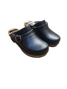 Experience Unmatched Comfort and Style;  Black Wooden Clogs crafted from natural cowhide leather, our 2mm-thick black colored clogs redefine comfort and elegance. The addition of an adjustable strap with a buckle ensures a snug fit, eliminating worries about fastening length. Glide through your day with ease, knowing these wooden shoes provide the perfect balance of support and flexibility. Premium Material, Superior Quality;  Step into luxury with our closed toe wooden clogs, meticulously designed for clogs women. The durable upper crafted from natural cowhide leather promises longevity, while the real wood and PU rubber bottom offer stability without the traditional clacking sound. Elevate your footwear collection with these premium, versatile clogs. Unleash Your Style Statement;  With t Black Closed Toe Mules With Leather Footbed, Black Leather Clogs With Buckle Closure, Black Leather Clogs With Removable Insole, Classic Black Mules With Buckle Closure, Black Clogs With Cork-bed Midsoles And Round Toe, Black Leather Clogs With Rubber Sole, Black Slip-on Clogs With Buckle Closure, Black Clogs With Wooden Heel And Round Toe, Black Leather Footbed Clogs With Round Toe