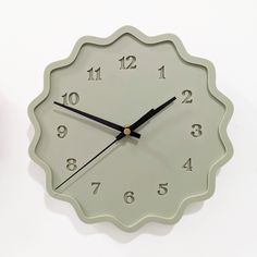 a clock that is sitting on the wall next to a vase with flowers in it