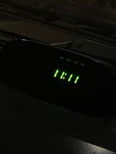 an electronic clock with the time 11 55 on it's display is lit up