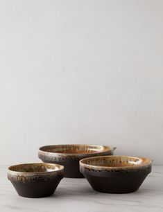 three black and white bowls sitting on top of a table