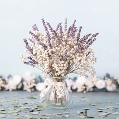 a vase filled with lots of white flowers on top of a table