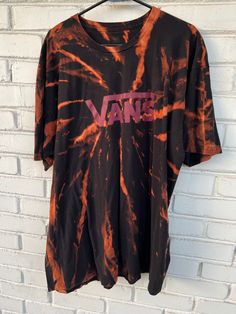 Step up your streetwear game with this unique and stylish Vans Reverse Tie Dye Shirt. Made from a high-quality upcycled tee, this shirt features a striking black and red reverse tie dye design that's perfect for skateboarders and streetwear enthusiasts. This shirt is perfect for anyone who wants to show off their individual style and love for streetwear fashion. The Vans logo on the front adds an extra touch of cool to this already stylish shirt. It's unisex design makes it a versatile piece that can be worn by anyone, and the upcycled tee material ensures that it's environmentally friendly and sustainable. sak The reverse tie dye design of this Vans shirt is eye-catching and unique, making it the perfect statement piece for any outfit. The shirt is comfortable and lightweight, making it p Casual Tie Dye T-shirt With Graffiti Print, Casual Tie-dye T-shirt With Graffiti Print, Tie-dye Cotton Tops For Streetwear, Tie Dye Cotton Tops For Streetwear, Casual Tops With Graffiti Print For Skateboarding, Tie Dye Graphic Print Top For Streetwear, Tie Dye Tops With Graphic Print For Streetwear, Casual Graffiti Print Tops, Tie Dye Screen Print Tops For Streetwear