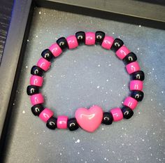 Edgy Adjustable Pink Jewelry, Adjustable Edgy Pink Jewelry, Casual Black Beaded Bracelets For Valentine's Day, Handmade Black Beaded Bracelets For Rave, Trendy Black Plastic Bracelets, Casual Black Heart-shaped Bracelets, Casual Black Heart-shaped Bracelet, Pink Plastic Rave Bracelets, Trendy Black Bracelets For Valentine's Day