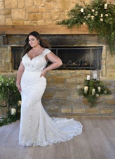 a woman standing in front of a fireplace wearing a wedding dress