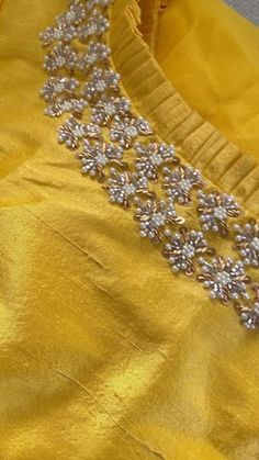 an image of a yellow dress with silver beads on it