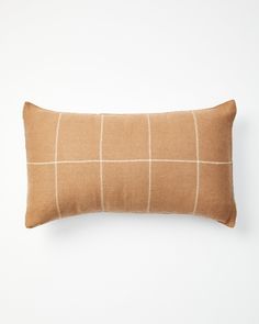 a tan and white checkered pillow on a white wall