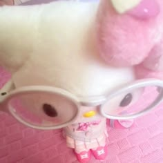 a stuffed animal wearing glasses on top of a bed