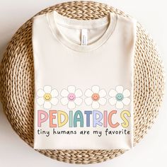 a white t - shirt that says pediatrics tiny humans are my favorite on it