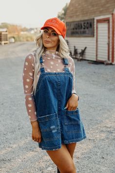 Introducing the must-have for any wardrobe: The Etta Dress. Made with durable denim and a boxy silhouette, this overall mini dress features a square neckline and detachable (and adjustable!) straps for ultimate style and comfort. The slightly distressed finish and western-inspired seam detail add a touch of unique flare. Courtney is wearing size small paired with the Daisy Mesh Top, American Cowgirl Trucker and Ariat Casanova Boots Western Trucker Hat Outfit, Cowgirl Fashion, Trucker Hat Outfit, Nashville Outfits, Western Outfits Women, Western Style Outfits, Professional Dresses, Dressed To Kill, Outfits With Hats