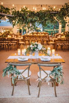 a table set up with candles and flowers for an outdoor wedding reception at the resort