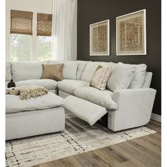 a living room with a sectional couch and ottoman