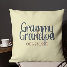 a white pillow with the words granny and grandpa est 2014 on it next to a coffee cup