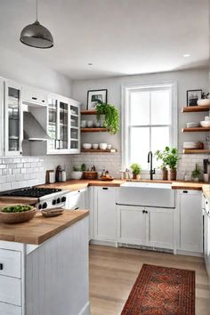 the kitchen is clean and ready for us to use it's white cabinets, wood counter tops, and open shelving