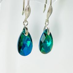 These elegant earrings feature shimmering Emerald Green Crystals that sparkle and catch the light beautifully. The crystals are suspended from a simple but stylish sterling silver base, which allows the stunning emerald green colour to take centre stage.  The overall drop length of the earrings is 37 millimeters, and each crystal measures 16 by 9 by 5 millimeters. These earrings are handmade and feature a timeless teardrop design, making them perfect for a range of special occasions. For those who love a complete look, there is a matching necklace available here www.etsy.com/uk/listing/1365706845.  If you have any questions or need assistance with anything, please don't hesitate to reach out to me. I'd be more than happy to help. Crystal Long Drop Earrings As Gift, Crystal Long Drop Earrings For Gifts, Crystal Teardrop Long Drop Earrings Gift, Faceted Crystal Teardrop Earrings, Long Drop Crystal Earrings For Gift, Sparkling Dangle Teardrop Earrings Gift, Sparkling Teardrop Dangle Earrings As Gift, Teardrop Crystal Earrings With Ear Wire, Teardrop Crystal Earrings As A Gift