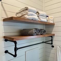 towels are stacked on two shelves in the bathroom