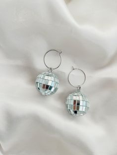 These Disco Ball Hoops are trendy, unique and hypoallergenic! Dimensions: 1x 2 in.  All items are made with love in Sacramento, CA. Earrings come on our silver hoops that are simple, lightweight and super comfy for all day wear. -- CARE -- We recommend removing jewelry before showering, swimming or sleeping to extend their shiny, wearable life. Scratches may occur during wear so be sure to keep them in a safe, dry place when not sporting them. Disco Ball Stud Earrings, Maximalist Jewelry, Funky Earrings, Earrings Trendy, Trendy Boho, Diy Crafts Jewelry, Hypoallergenic Earrings, Disco Ball, Fun Earrings