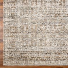 an area rug with wood flooring in the middle and beige tones on top of it