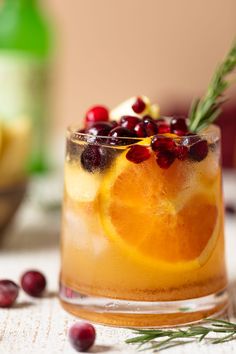 a drink with orange slices and cranberries in it