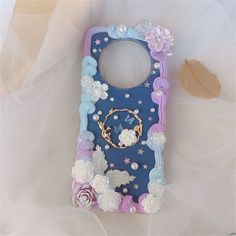 a cell phone case with flowers and pearls on it, sitting on a white surface