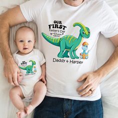 Get ready to roar into Father's Day with our adorable collection of matching tees, specially designed for first-time dads and their little dino buddies! Introducing our "Our First Father's Day Together" shirts, crafted to celebrate this special milestone in style. 👕 These matching tees aren't just outfits; they're tokens of the bond between a dad and his dino-loving sidekick. With "Our First Father's Day Together" proudly displayed on the front, these shirts are the perfect way to mark the begi Playful Father's Day T-shirt For Family, Father's Day Cartoon Print Crew Neck T-shirt, First Birthday T-shirt With Dinosaur Print, Crew Neck T-shirt With Dinosaur Print For First Birthday, Dinosaur Print Short Sleeve T-shirt For First Birthday, Father's Day Playful Short Sleeve T-shirt, Funny Character Print T-shirt For Father's Day, Playful Crew Neck T-shirt For Father's Day, Playful Father's Day Family T-shirt