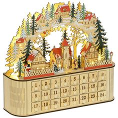 a wooden calendar with houses and trees on the front is lit up in christmas lights