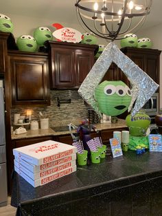 the kitchen counter is covered with boxes and decorations for an alien themed birthday party at home