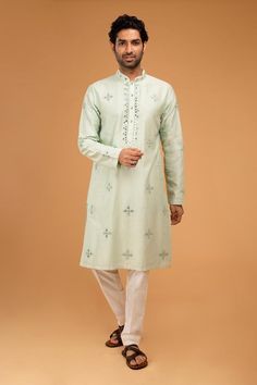 Mint green full sleeve kurta with mirror placement embroidery and mandarin collared neckline. Paired with pyjama pant.
Components: 2
Pattern: Embroidery
Type Of Work: Mirror
Neckline: Mandarin collar
Sleeve Type: Full sleeves
Fabric: Cotton Silk
Color: Green
Other Details: 
Front button detailing
Occasion: Mehendi and Puja - Aza Fashions Mint Green Mirror, Kurta And Pants, Embroidery Mirror, Blouse Yoke, Kurta Set For Men, Green Mirror, Green Mirrors, Pajama Pant, Silk Embroidery