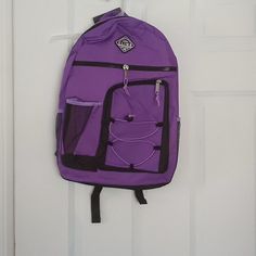 a purple backpack hanging on a white door