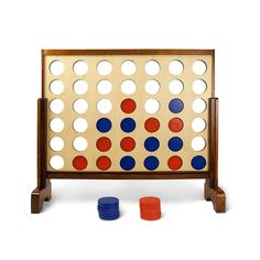 a giant four in a row board game with blue, red and orange discs around it