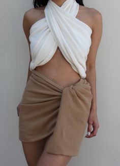 The Ellie Sarong is our most versatile piece yet and was inspired by our love of waffled cotton, which we wanted to make available in as many styles as possible. We envision the Ellie as a year-round accessory that can be tied as a halter or bandeau top, easy sarong skirt or cover-up, or draped as a classic shawl or scarf. Ideal for a variety of settings - from everyday summer comfort to luxurious resort wear. Pair with coordinating Bobbie Wrap Skirt, Chloe Shorts, or Patricia Pants for a sophis Versatile White Halter Top, White Cotton Tie-back Halter Top, Scarf Skirt, Honeycomb Texture, Luxurious Resort, Sarong Skirt, Bandeau Top, Sarong, Wrap Skirt